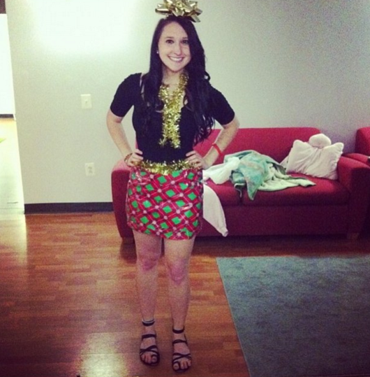 girl wearing wrapping paper and a bow