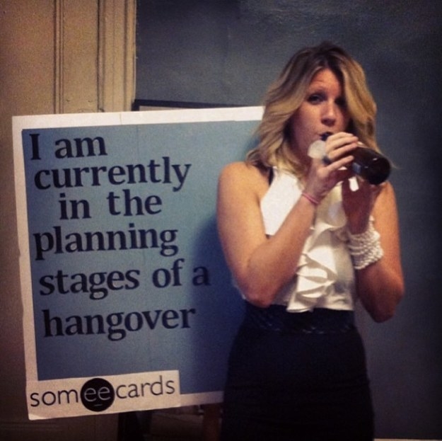 girl drinking with a sign that says &quot;I am currently in the planning stages of a hangover&quot;