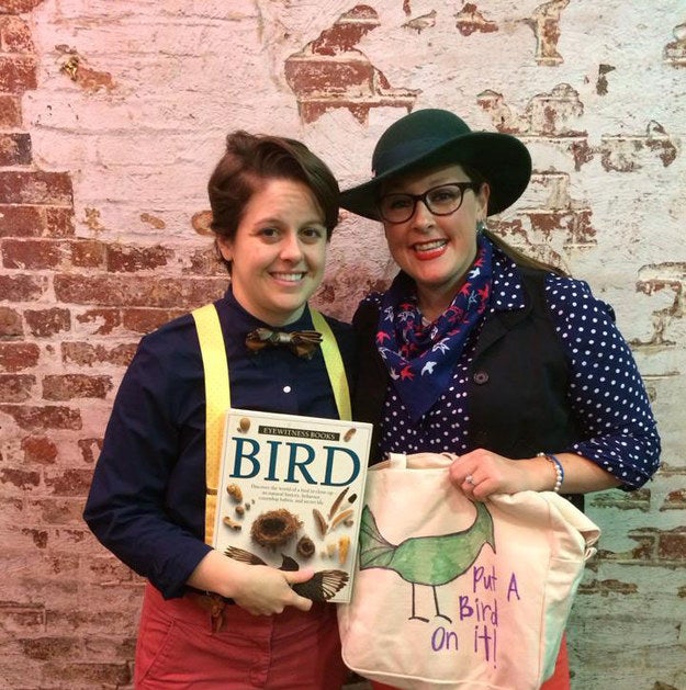 One person wearing suspenders and holding a book and one person wearing a polka dot shirt