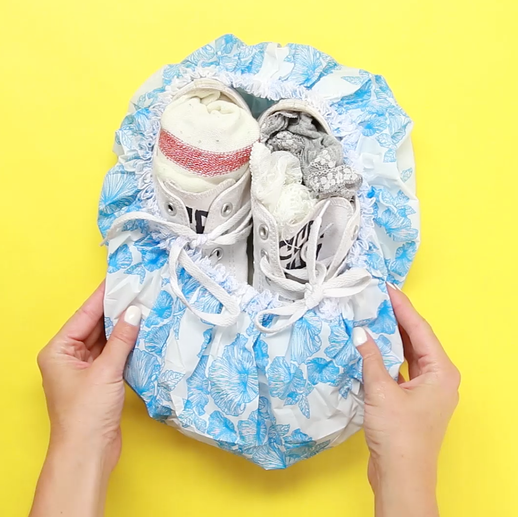 a pair of shoes in a shower cap with socks and undies inside them