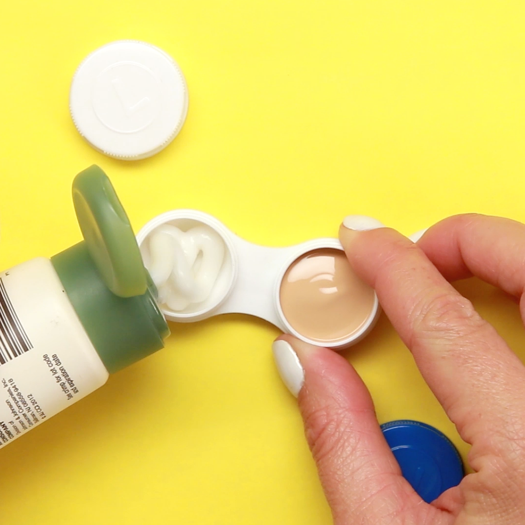 a contact lens case being filled with lotion on one side and makeup on the other side