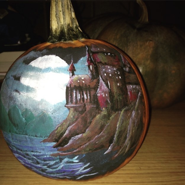 a painted pumpkin showing a house on a cliff