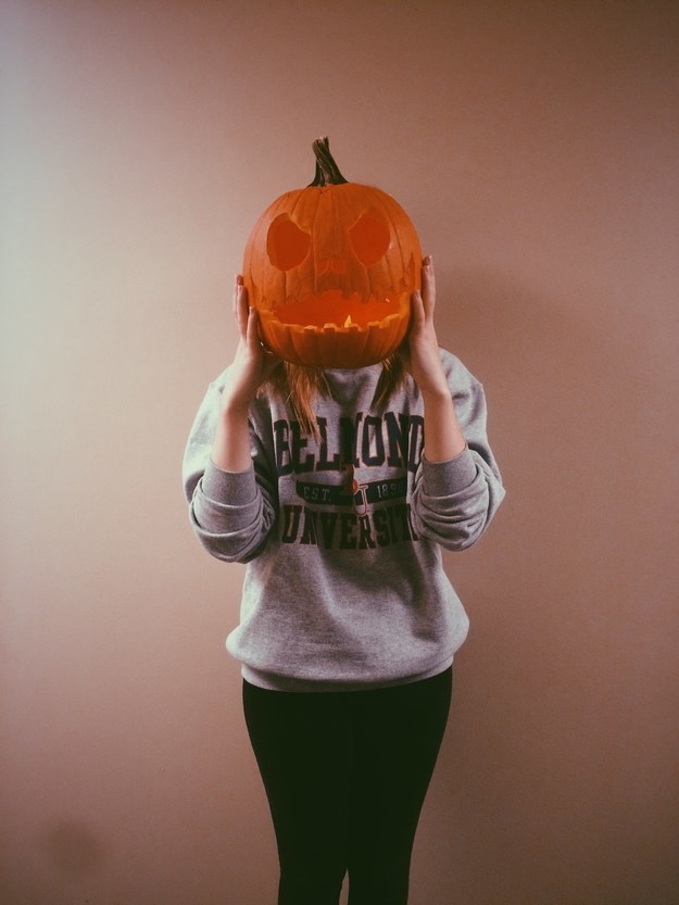 a person wearing a pumpkin on their head
