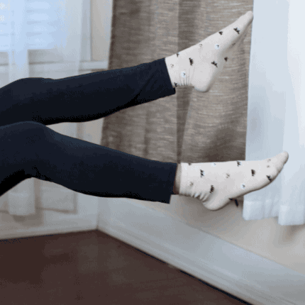 Sit on the chair and lean back slightly, holding the sides of the seat for support. Then, extend both legs and alternate as you cross one leg over the other.