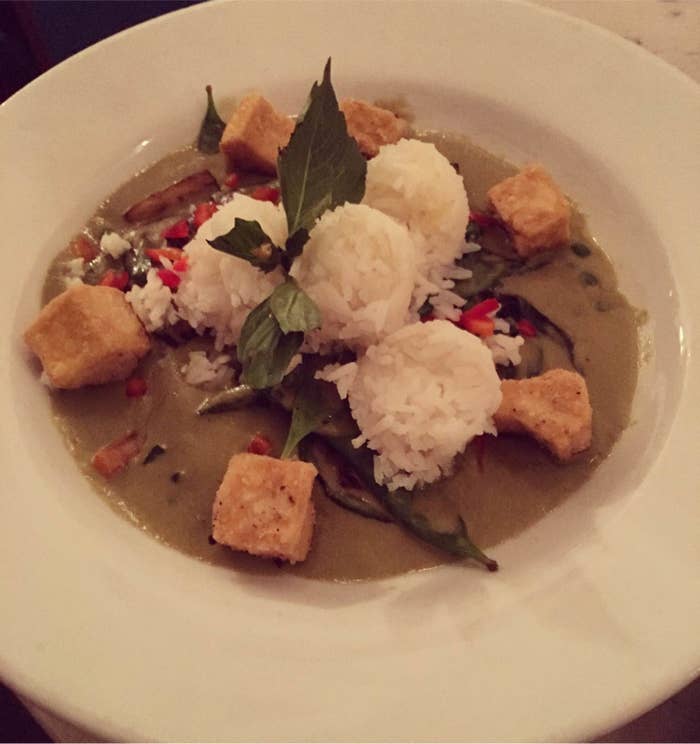 The rich and creamy Green Curry is made with coconut milk infused with lemongrass, galangal, makrut lime leaves, and Thai basil with green peas, sweet peppers, fresh garlic, Japanese eggplant, and crispy fried tofu. It is served with four "scoops" of jasmine rice. For those with high heat tolerance, you can order the dish "spicy as hell."