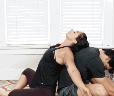 Sitting back to back, bring your two heels to touch. As your partner bends forward towards their heels, bend backwards with their back as support. Then do the same for your partner!