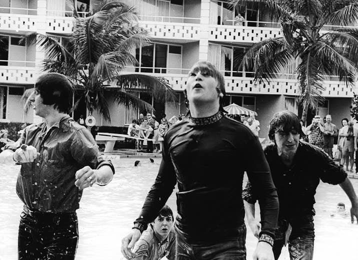 Members of the Beatles climb out of a pool during the filming of Help! in Nassau, Bahamas. From left: Ringo Starr, Paul McCartney (in background), John Lennon, and George Harrison.
