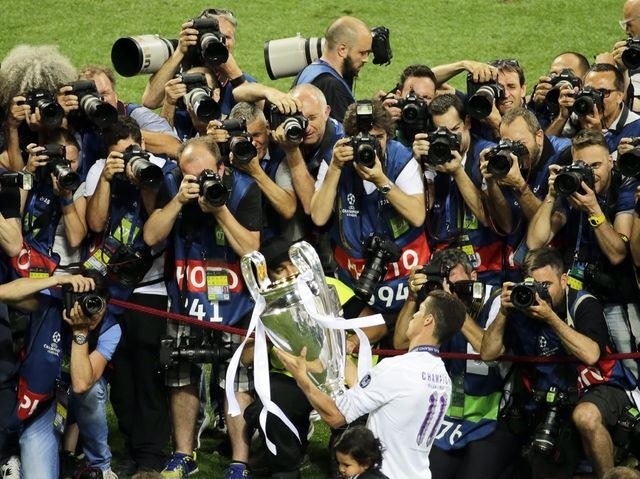 Fotógrafos disputam o clique de Cristiano Ronaldo com a taça da Liga dos Campeões, em maio