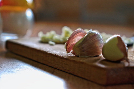 To loosen the garlic's skin, pound each clove under the flat side of the knife.