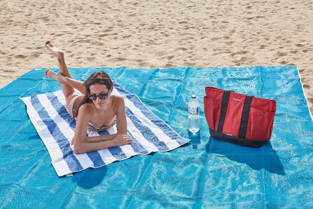 Promising review: "This is the best beach blanket you could ever own! All dry sand runs right through it. If it piles up, just lift it up a little and put it back down. Wet sand stays on tops until it dries, then when you run your hand across it, it falls through. I would recommend it very highly!" —Mike PattersonGet it from Amazon for $40+.