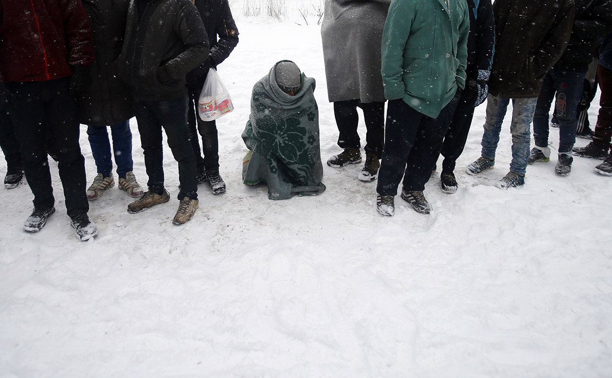 Migrants queue for food in front of an abandoned warehouse in Belgrade, Serbia, on Jan. 11. Hundreds of migrants are sleeping rough in parks and make-shift shelters in the Serbian capital in freezing temperatures waiting for a chance to move forward toward the European Union.
