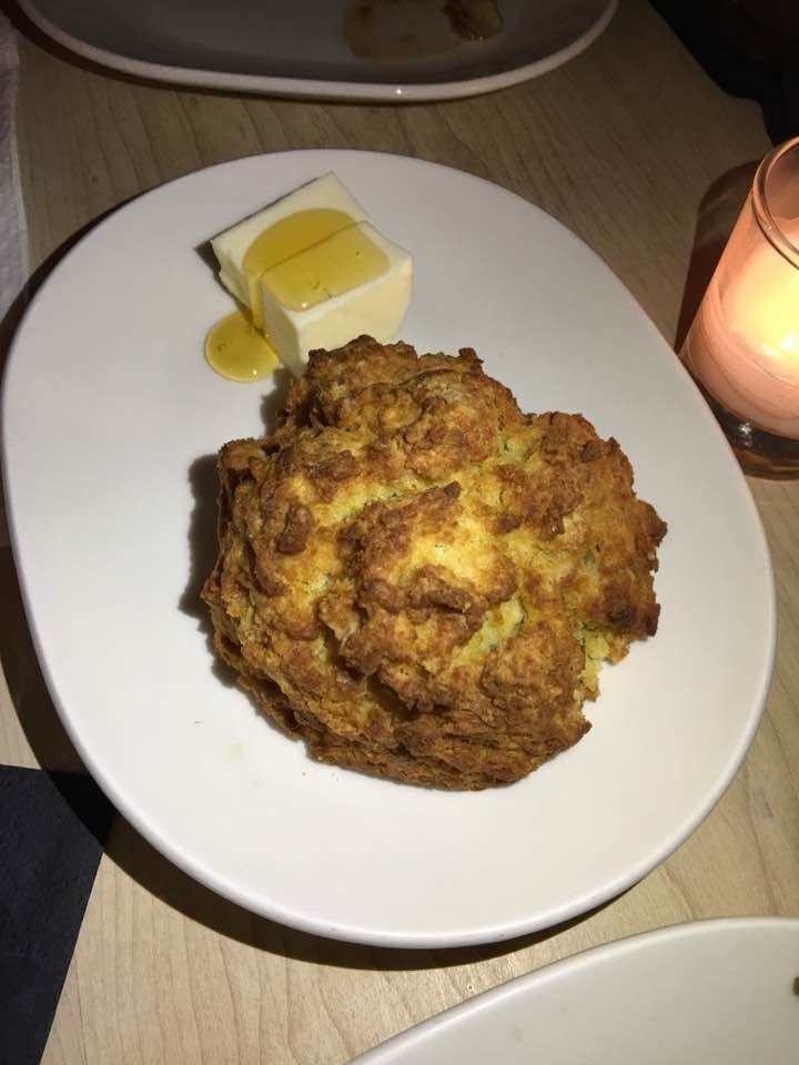 The side of dense buttermilk biscuit is a must. The biscuit has crispy exterior with moist interior. It is served with a side of butter topped with a drizzle of honey.