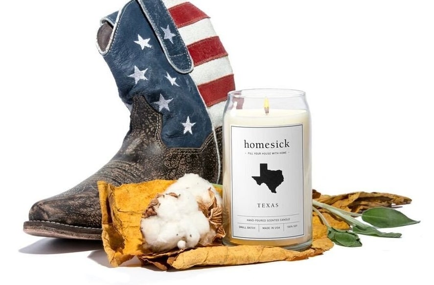 the Texas homesick candle next to a cowboy boot