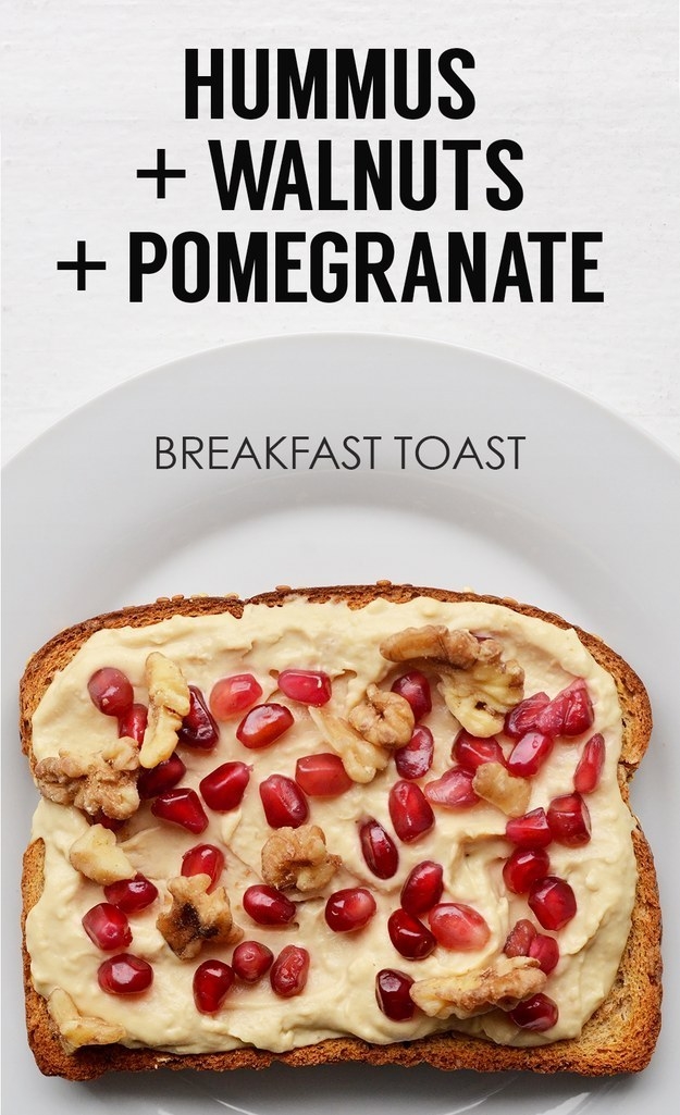 toast with hummus spread on it and topped with walnuts and pomegranate seeds