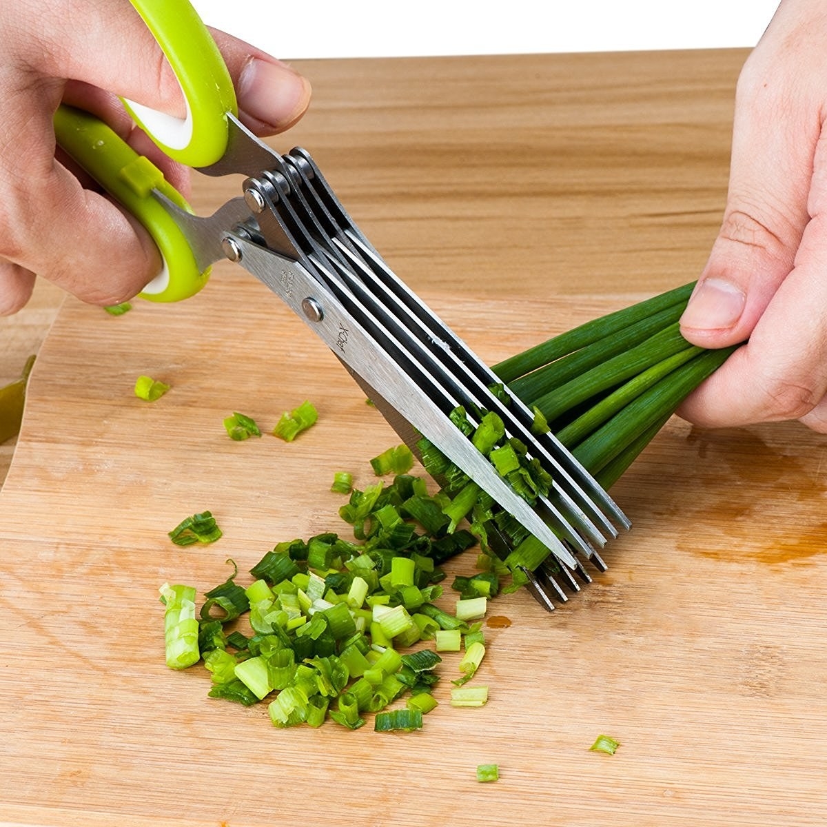 person chopping green onions with special scissors that have multiple blades