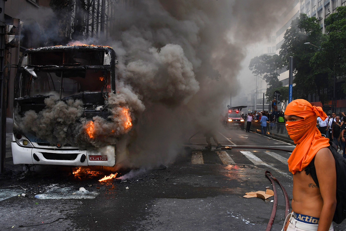 Brazilian civil servants protesting against austerity measures clash with riot police and set fire to a bus on Rio Branco, the main avenue in Rio de Janeiro, Brazil, on Feb. 1.