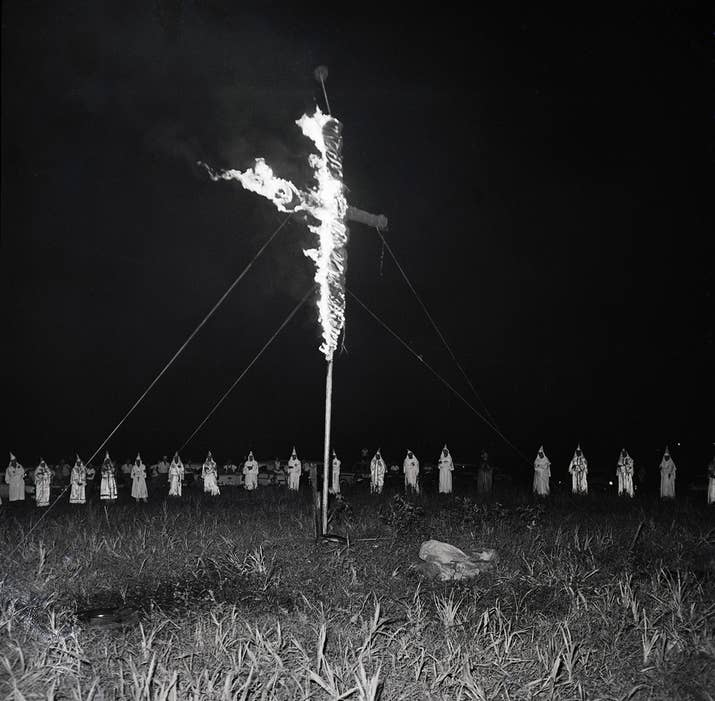 Klansmen form a circle around a burning cross at a rally in Albany, Georgia, which an estimated 3,000 persons attended in 1962.