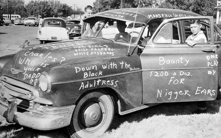 Roy Lee Howlett, 14, stands beside a car painted with signs protesting the desegregation of Mansfield High School in Dallas on Aug. 31, 1956.