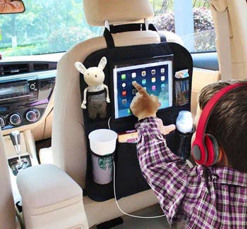 The organizer holding an iPad, stuffed animal, coffee cup, etc. while child uses the iPad
