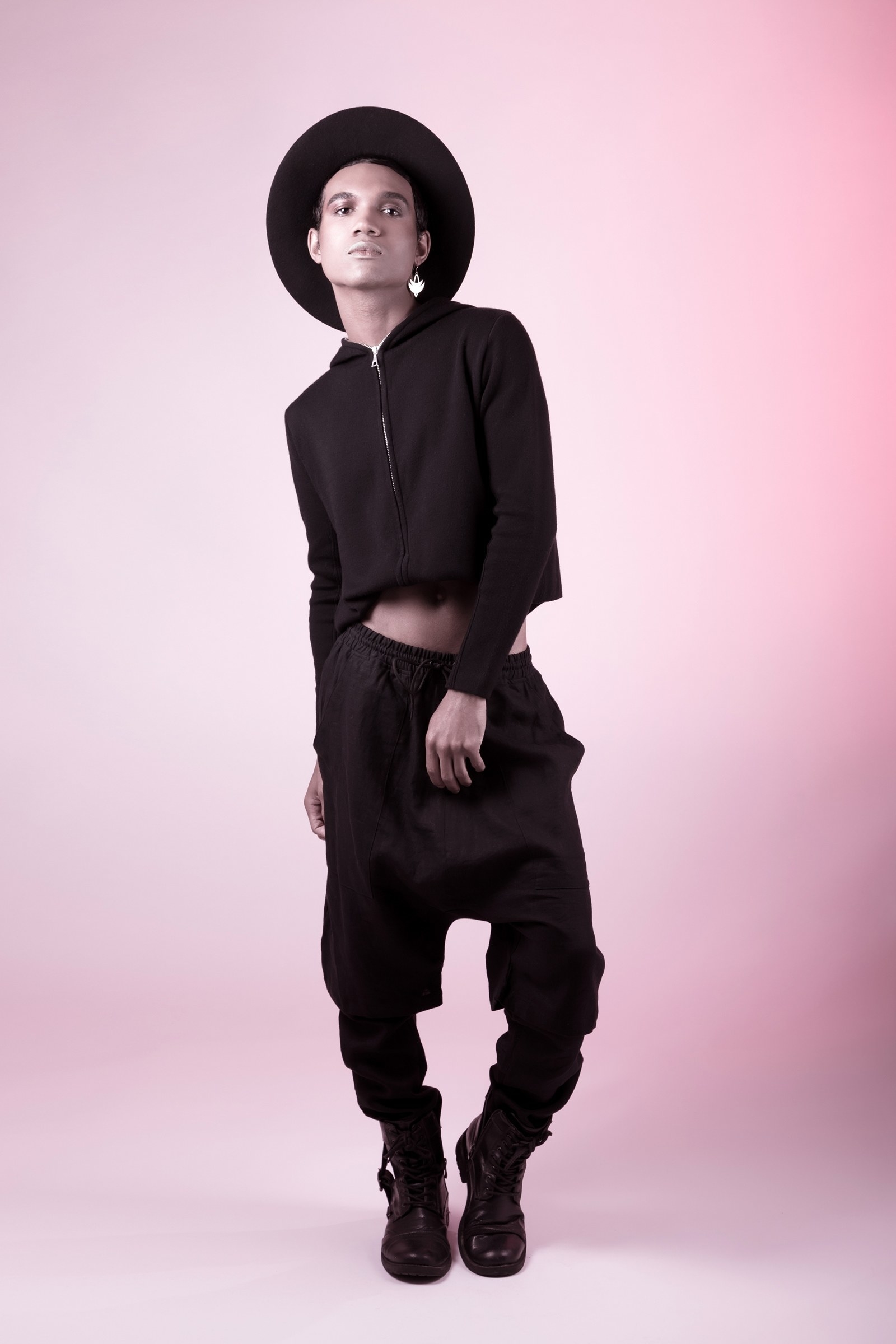 We wanted something very fun and still grunge. So look three Roman sports a dramatic hat which is very in. However we took the look further with a crop-top sweat shirt and harem pants. Kai Pritchard (MUA) kept the face very simple adding red elements to the eyes and contouring out the cheeks to give a very indigenous look. We really play with the fluidity of sexuality and ethnicity with this look. Paolino’s lighting genius creates a fun image, to a look that would otherwise be considered serious.