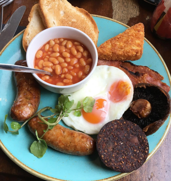 Um tradicional café da manhã inglês consiste em ovos, torrada, feijões, linguiças e um tipo de chouriço.
