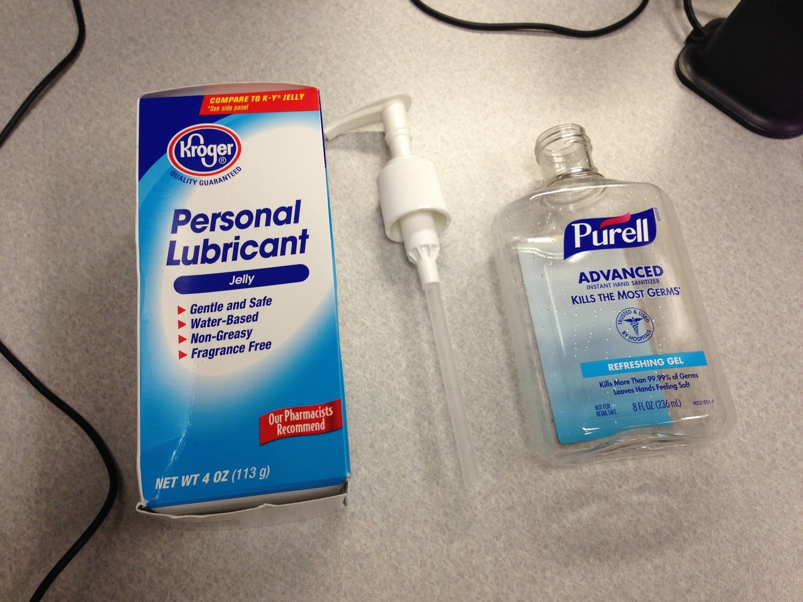 Kroger brand personal lubricant next to a Purell hand sanitizer bottle on a desk