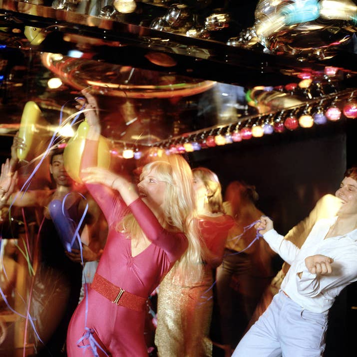 A group of partygoers join in a synchronized dance number in an unidentified club, circa 1977.