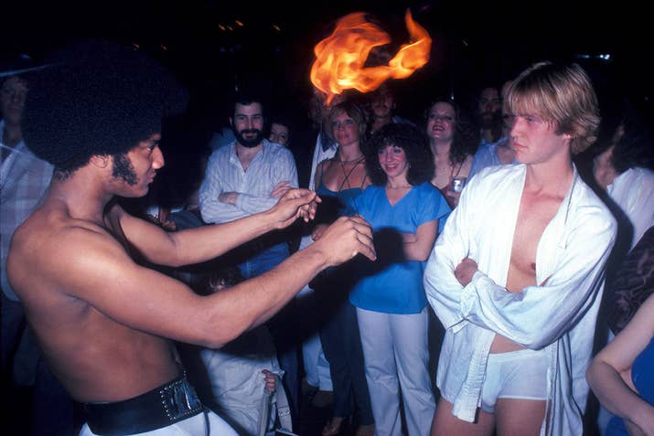 A man performs with fire at the disco club Infinity in New York City, 1979.