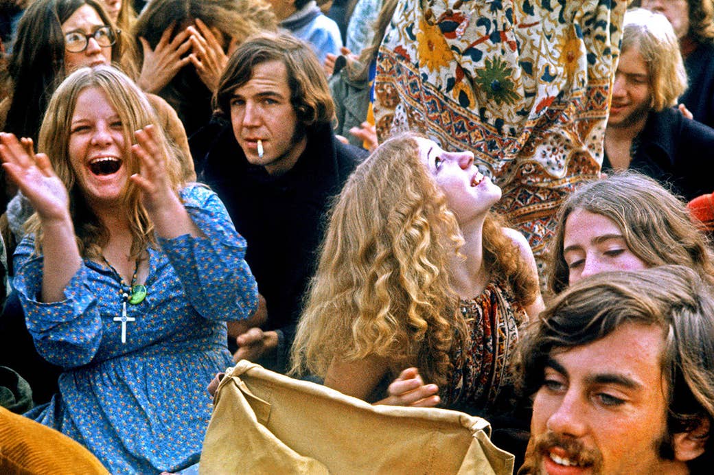 Os povos no elogio da multidão enquanto os atos musicais executam no festival livre do estrada de Altamont o 6 de dezembro de 1969, em Livermore, Califórnia.