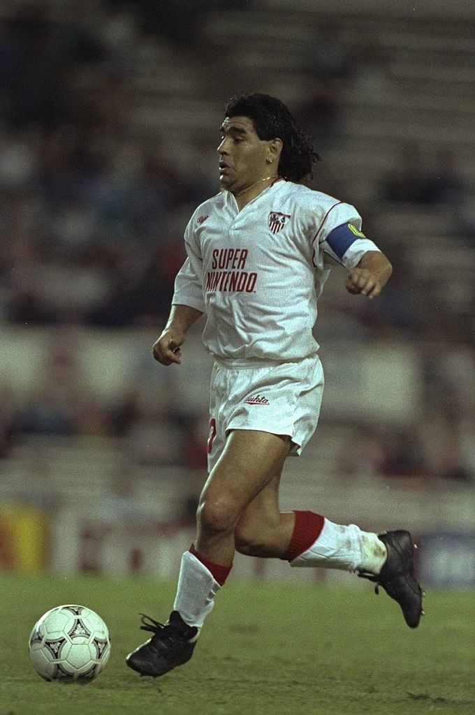 Diego Armando Maradona durante un partido entre el Sevilla y el Bayern de Munich. Con publicidad de Super Nintendo.