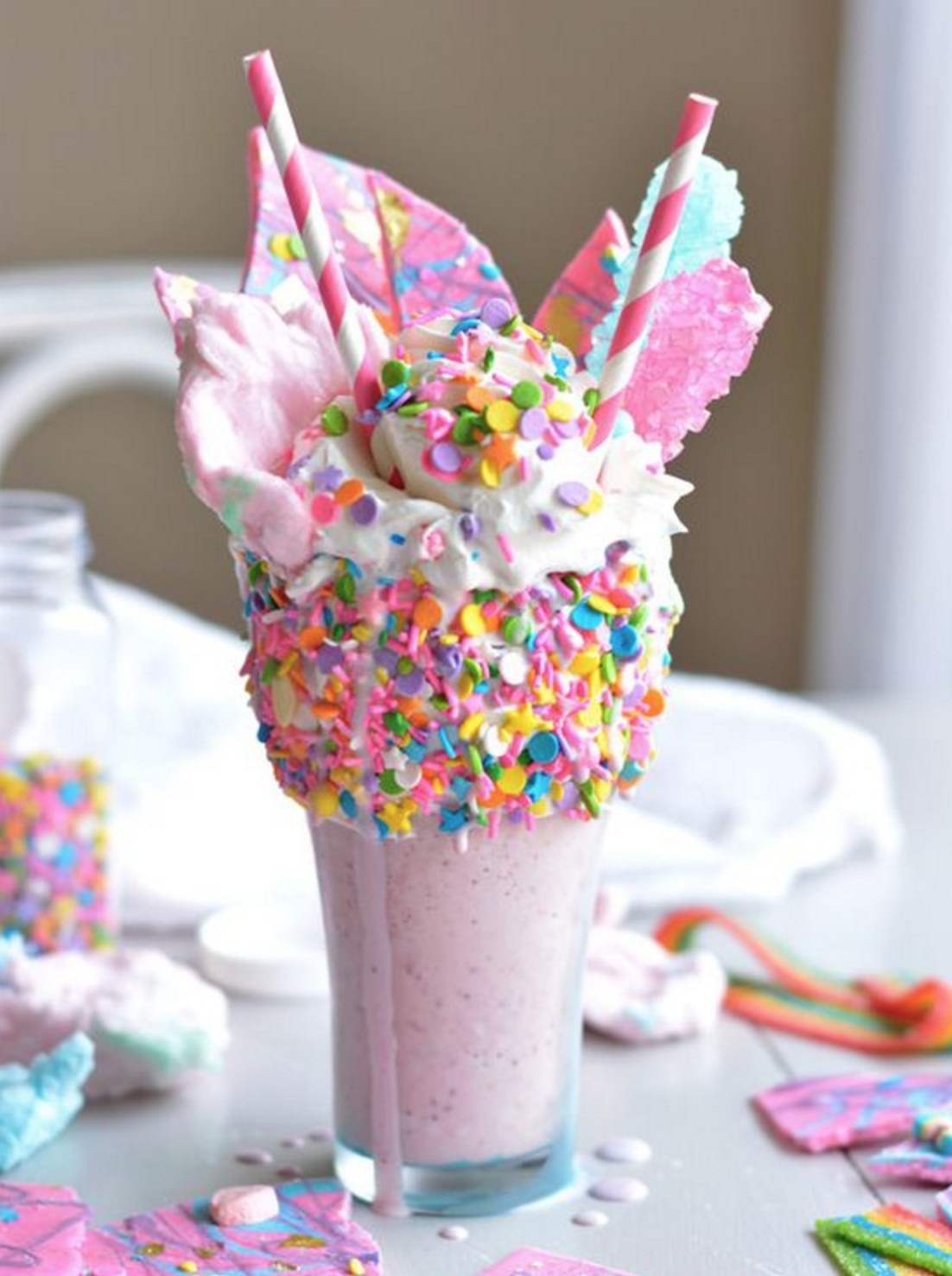 This is the ultimate strawberry milkshake straight from candyland. It is topped with glittery rainbow bark, rock candy, and sprinkles.