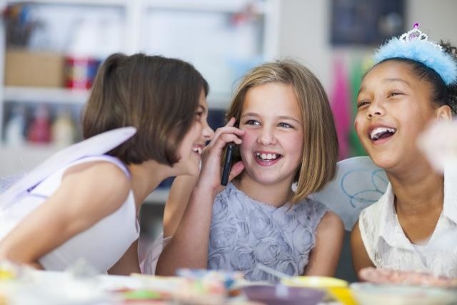 Middle childhood is the time were children make friends that like the same things as them and create close friendships. How they spend their time together can vary between gender. Girls are more likely to play indoors, while having a small friend group. They spend their time agreeing on different topics. This picture displays the typical way girls hangout during middle childhood. They are indoors, with a small group, conversing, and enjoying each other's company.
