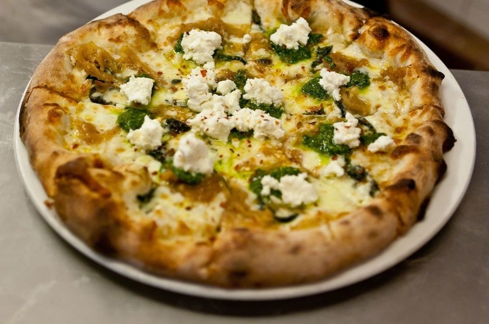 A Mediterranean-inspired pizza with feta cheese, artichokes, kalamata olives and pesto. You can find a recipe for home made pizza dough here as well.