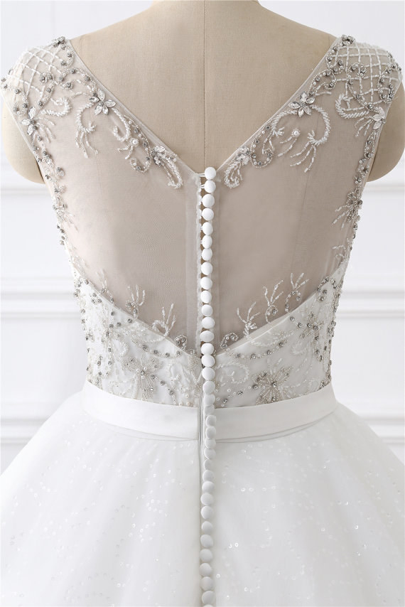 This stunning illusion bodice embellished with sequins, beads, pearls, and covered buttons.