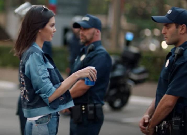 The police officer takes a sip, looks at his fellow cop, and smiles – as if to say, 'Hey, maybe we should protest too?'And this is only the shortened version of the ad. There's a ~2.5-minute special as well that features a woman in a hijab looking at photos and a man playing the cello.