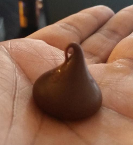 Close-up of an unwrapped Hershey&#x27;s Kiss in the palm of a hand