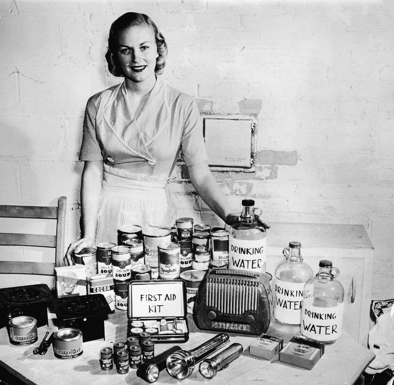 A model poses with a display of bomb shelter supplies in the 1950s.