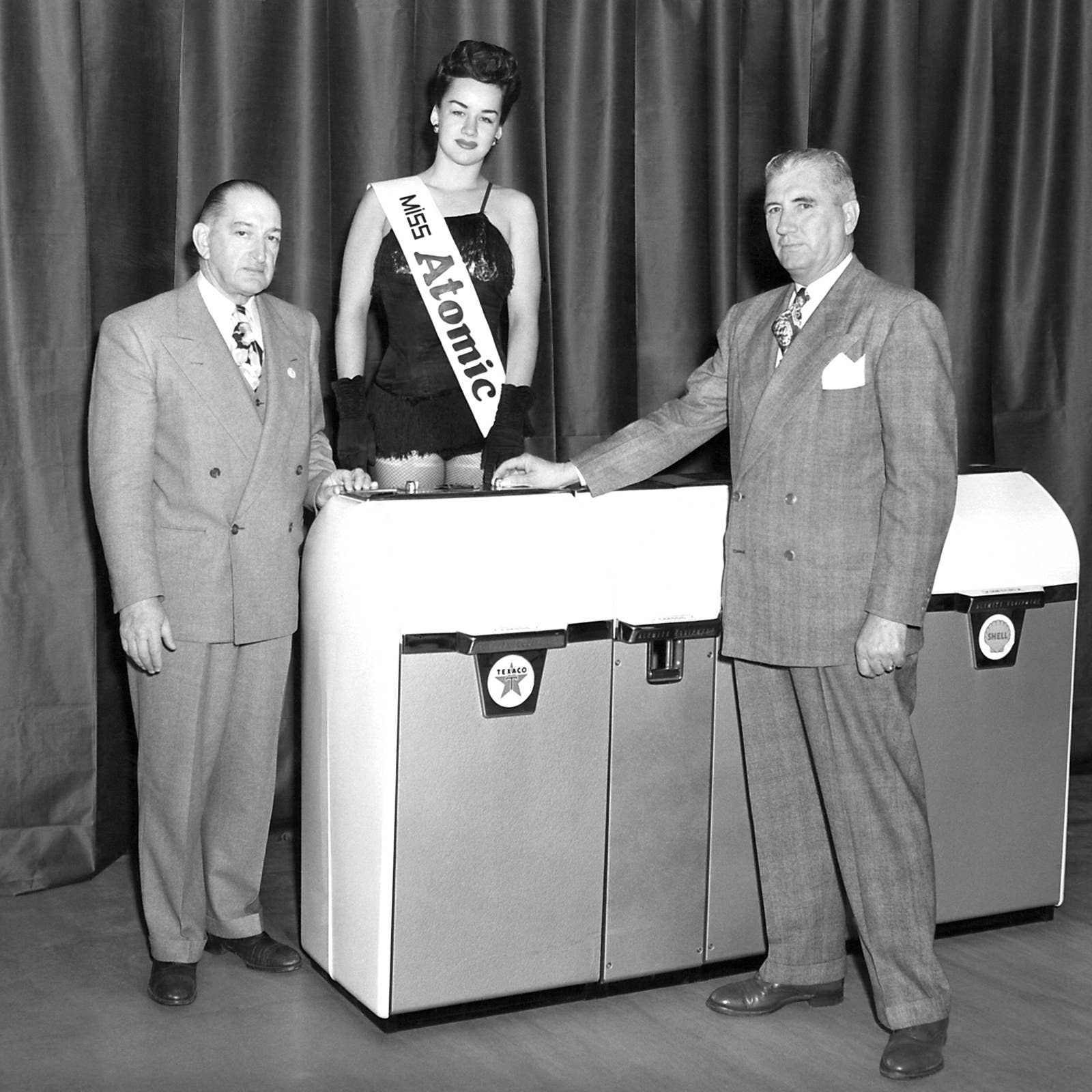 The winner of the 'Miss Atomic' beauty contest poses with two businessmen in 1955.