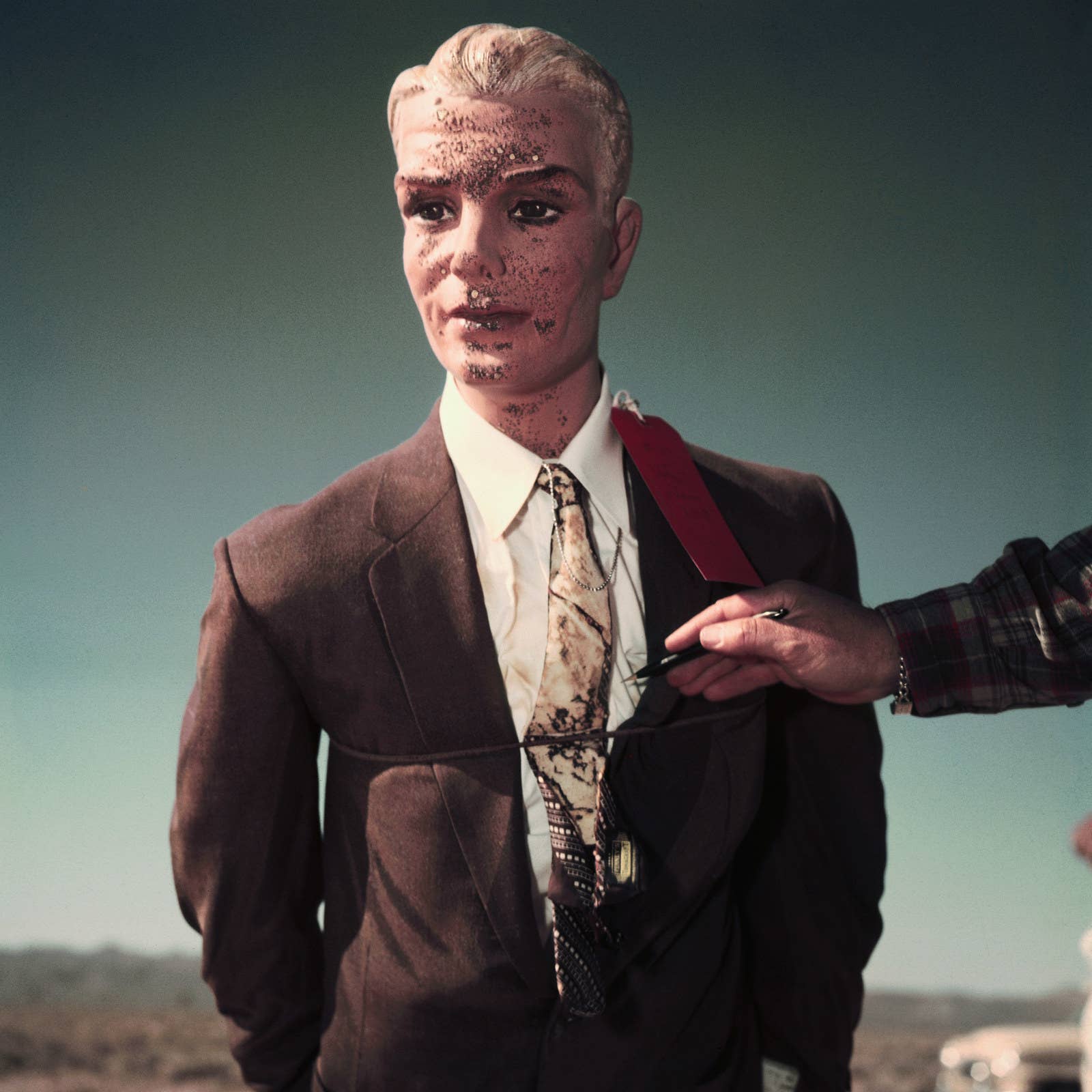 A government worker highlights the effects from an atomic bomb on a test dummy placed 7,000 feet from the explosion.