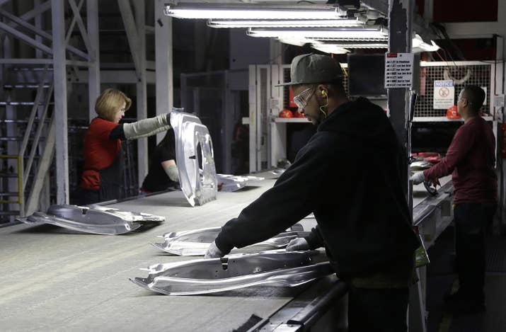 Tesla employees work in the Tesla factory in Fremont, Calif., Thursday, May 14, 2015. (AP Photo/Jeff Chiu)