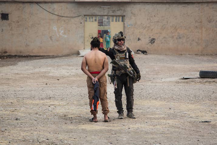 An Iraqi special forces soldier with an ISIS suspect.
