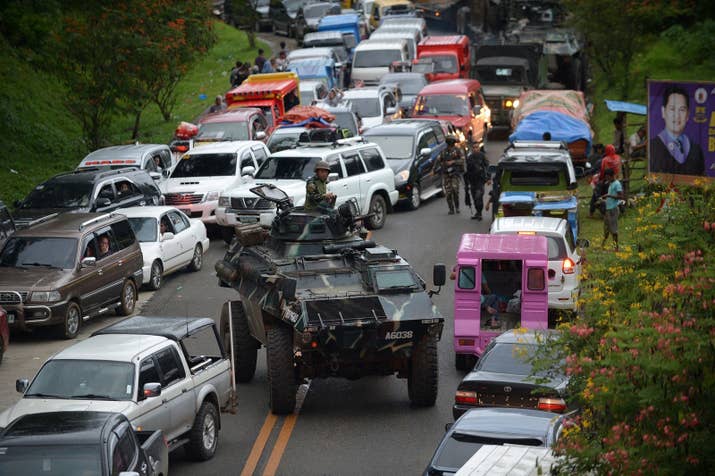 An armored personnel carrier moves amongst stuck vehicles of residents fleeing Marawi, in the southern island of Mindanao on May 25, 2017, as fighting rages between government forces and gunmen who have pledged allegiance to the Islamic State group.