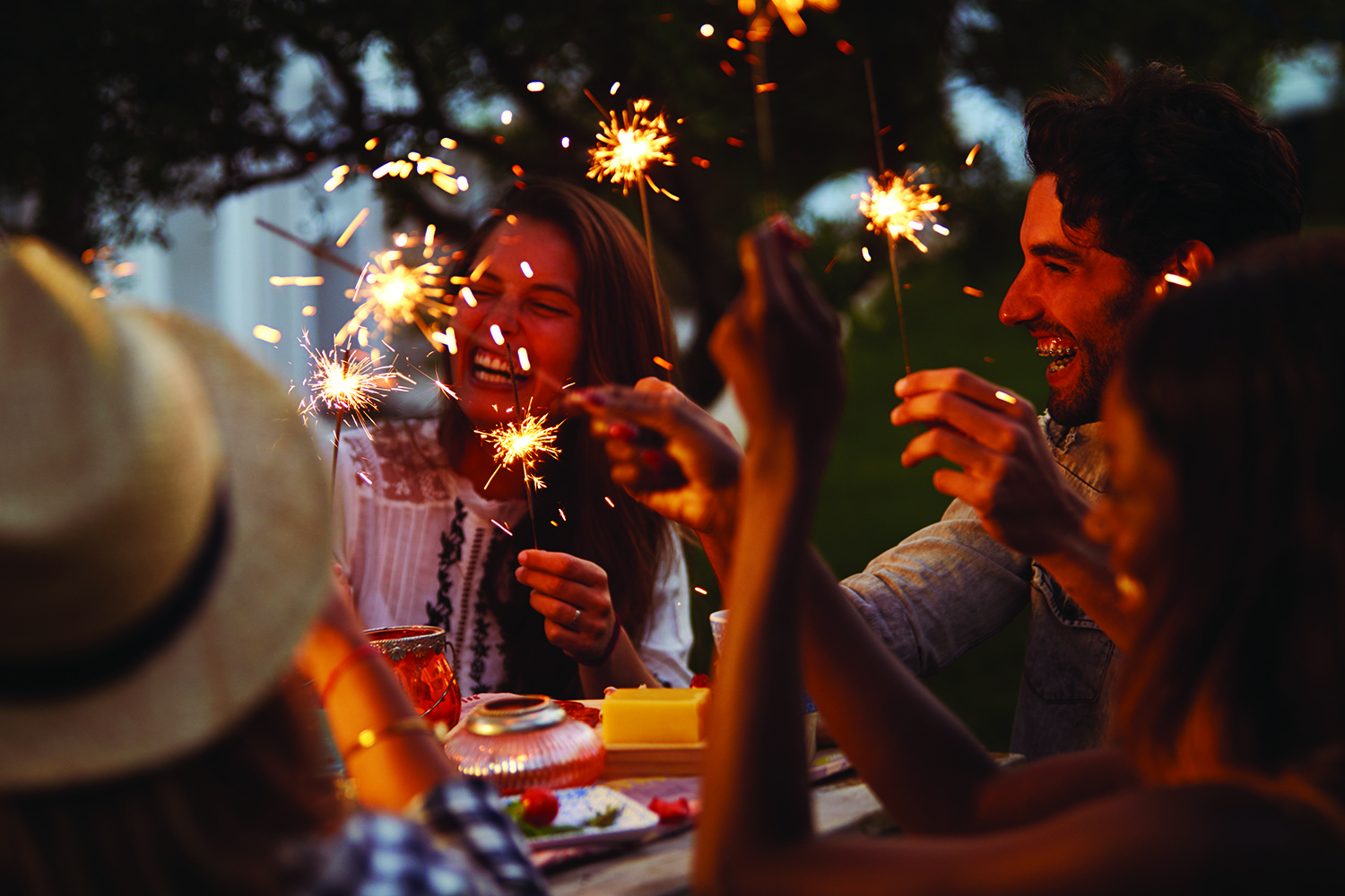Friends With Sparklers Eating Food And Enjoying Party