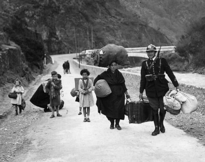Un soldado francés ayuda a una familia de refugiados a cruzar la frontera en 1938.