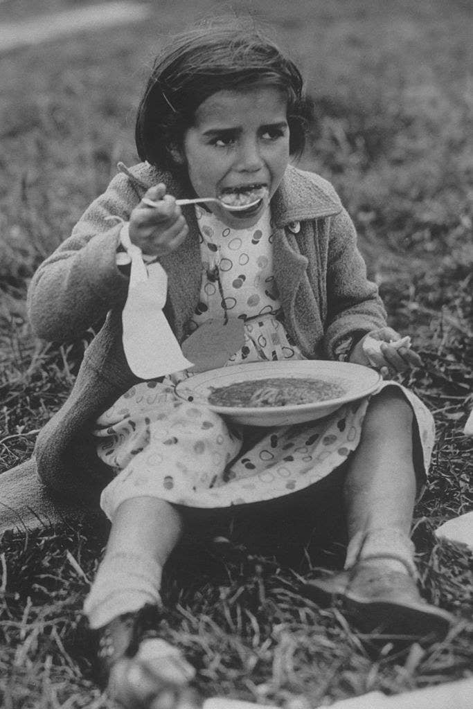 Una refugiada española, con su primera comida tras llegar a Inglaterra (1938).
