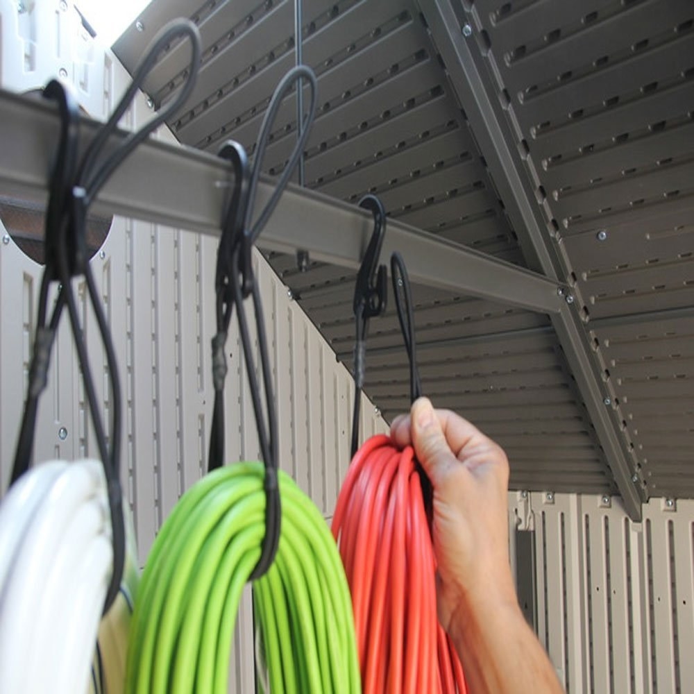 person hanging up a looped extension cord in a bungee cord hanging from a rafter