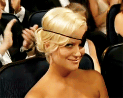 Liz Poehler in an audience wearing an eye patch and winking