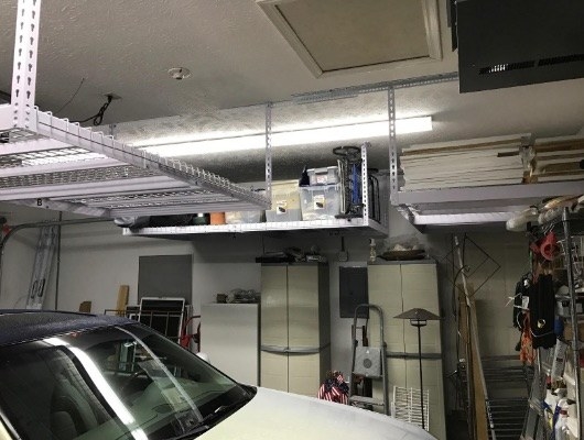 reviewer pic of the lofted storage racks hanging from a garage ceiling