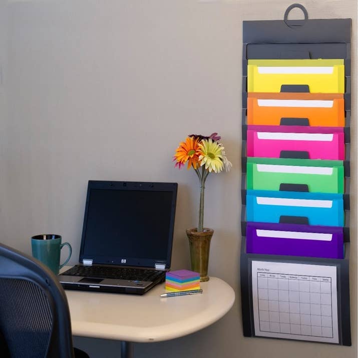 You can easily take if off the wall and close it with the attached elastic cords for on-the-go use, too!Get it from Amazon for $8.54.Promising review: "This hanging folder set is EXACTLY what I've been needing. I ripped the calendar off the wall and put it right up the moment I got it. It immediately went to good use and cleared up my cluttered desk full of various paperwork. Love the color-coded folders. Although I was worried about how flimsy it might be, it seems sturdy and well made." —Karen