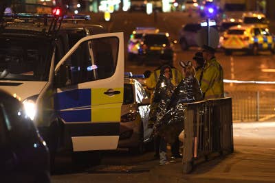 Concertgoers wait to be picked up at the scene of a suspected terrorist attack during a pop concert by US star Ariana Grande in Manchester.